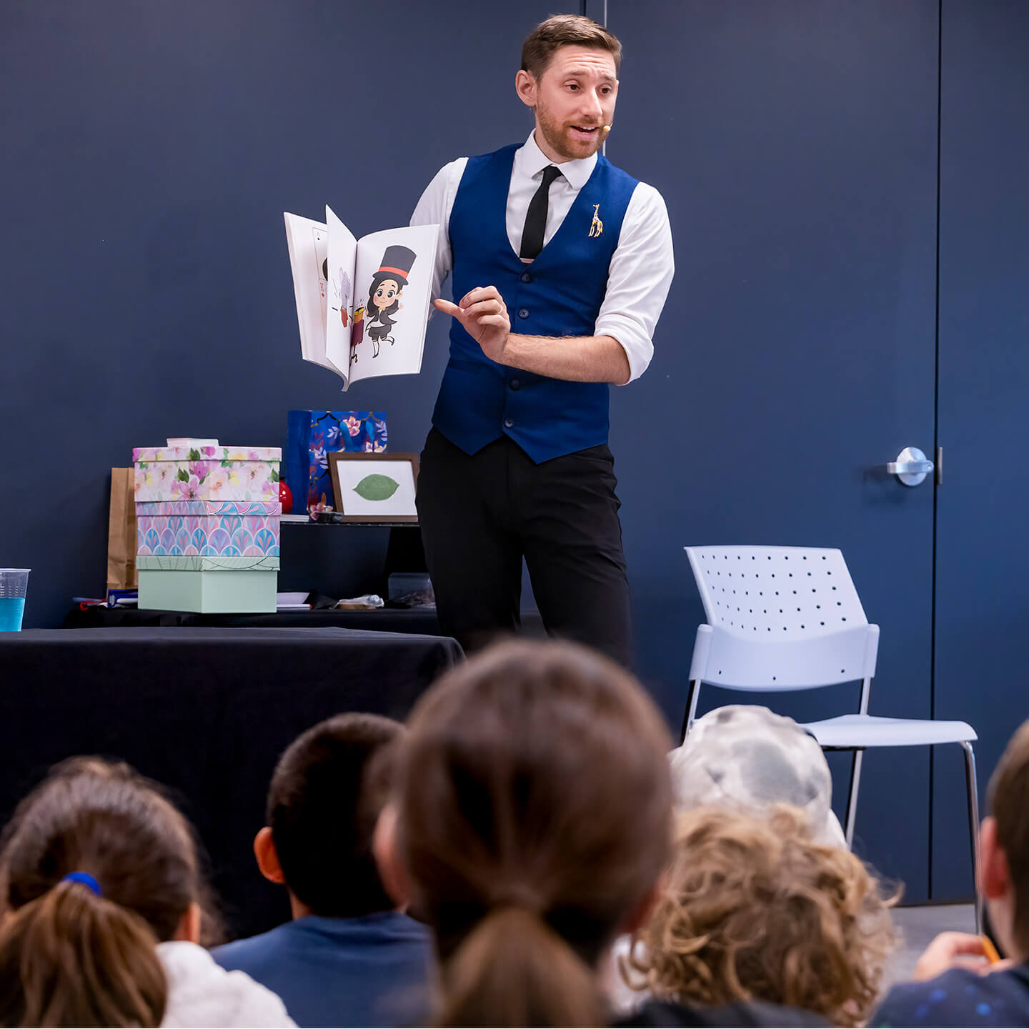 Group of children watching intently as Vincenzo performs at the Library.